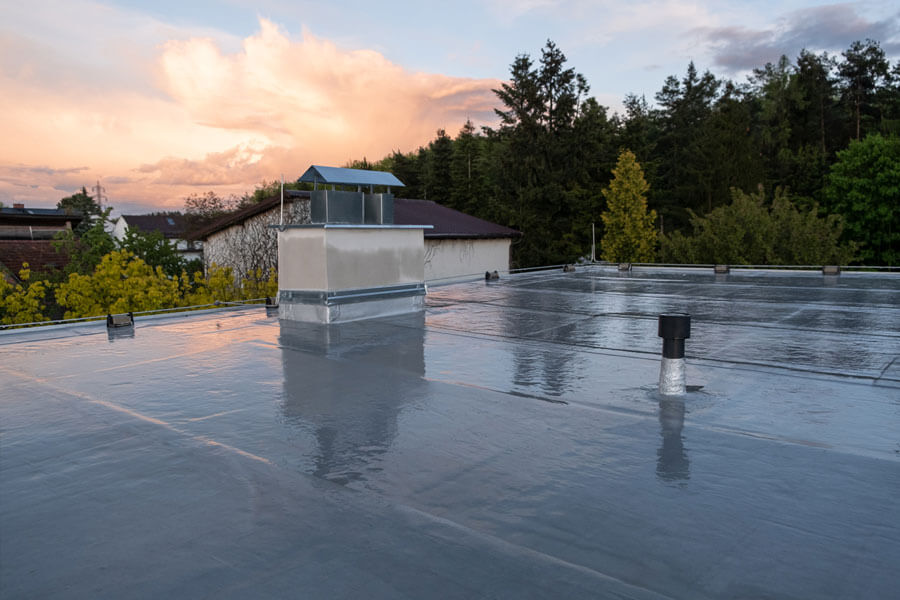 new coating on commercial roof at sunset